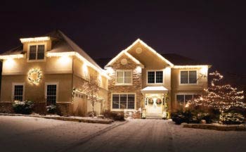 Two-story house in Eagan, Minnesota with white lights along the roofline and landscape