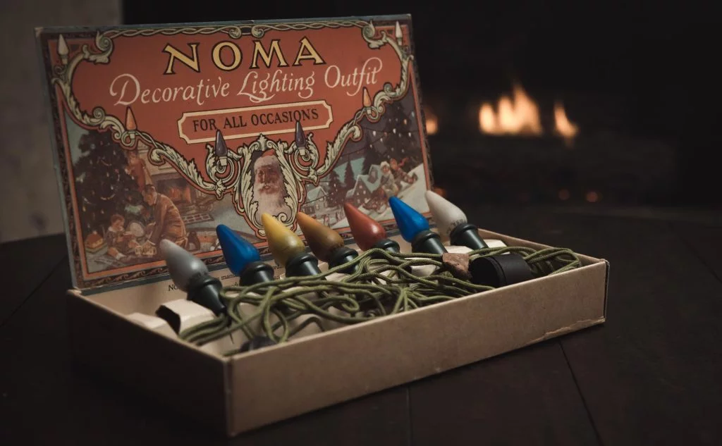 Vintage Christmas Lights in original packaging with a cozy fire in the background