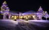 Purple and gold holiday lights on one story home in Plymouth, including three large trees and four shrubs wrapped.