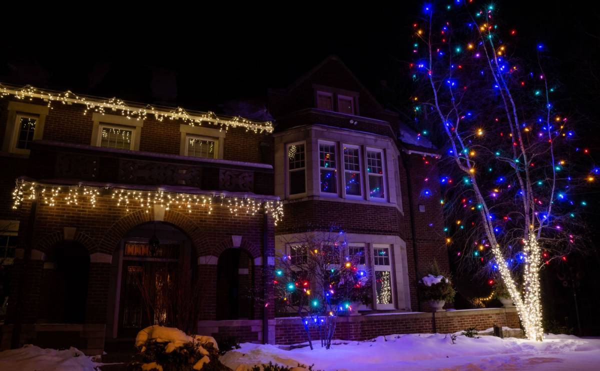 Icicle lights ion two story roof line with multi-color tree drape in St. Paul, Minnesota
