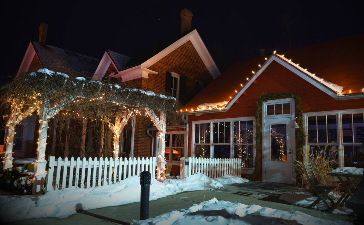 Warm white Christmas lights on home and pergola